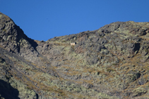 Nous observons en tout petit, dominant le cirque du Pla de l´Estany depuis les hauteurs, le refuge en bois des Estanys Forcats.