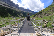 Traverser un petit pont métallique qui aide à surmonter un torrent.